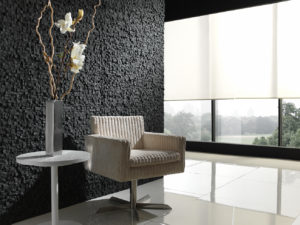 white chair and side table against black panel stone wall