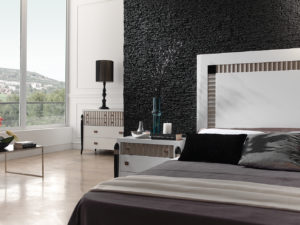 bedroom with white bed and black panel stone wall