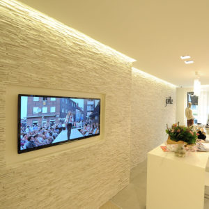 television hanging against white imitation stone panels