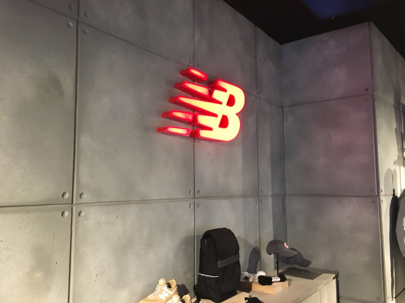 glowing red sign against grey faux concrete wall