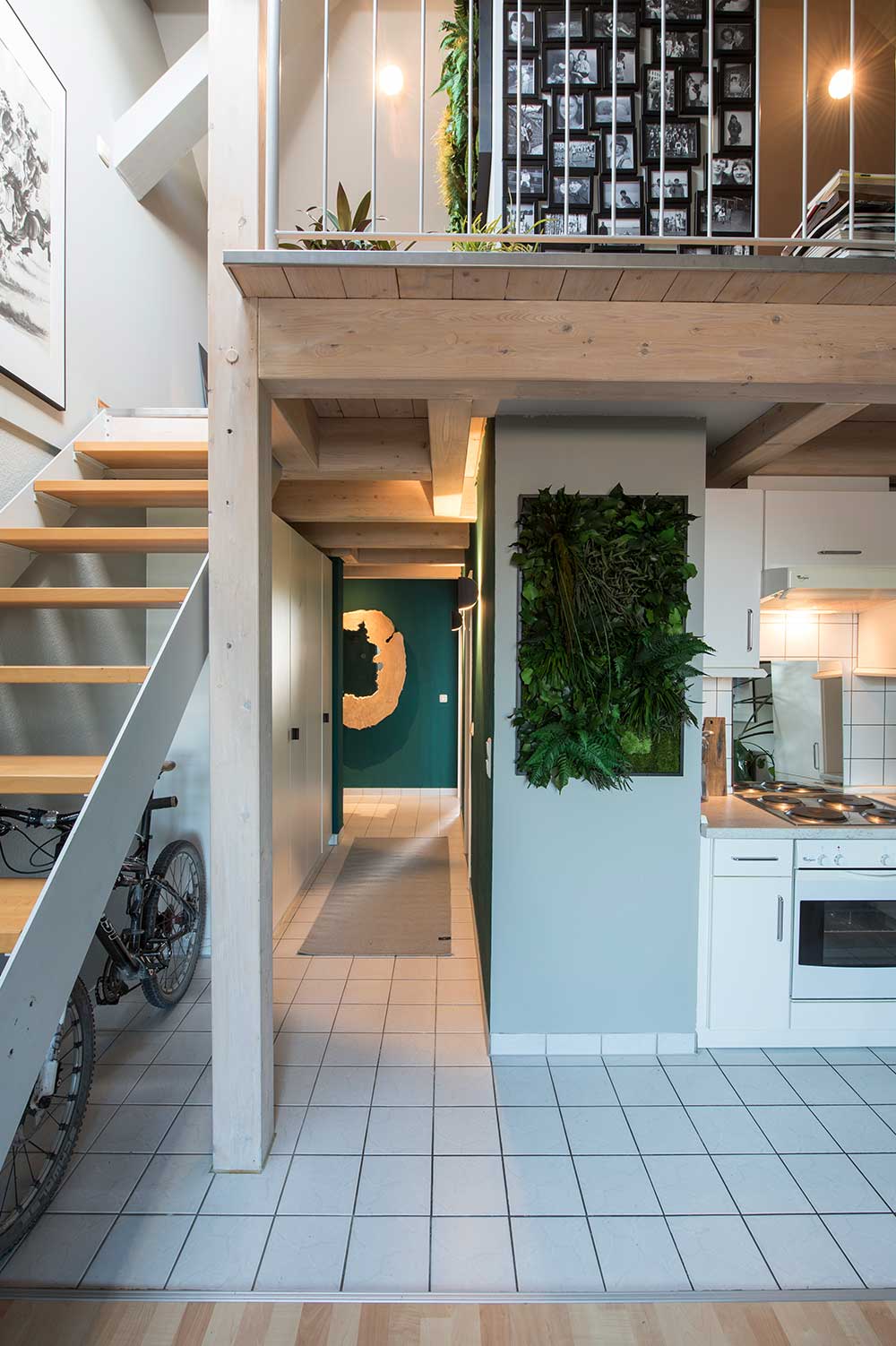 house with a wall next to the kitchen having a frame of greenery hanging from it