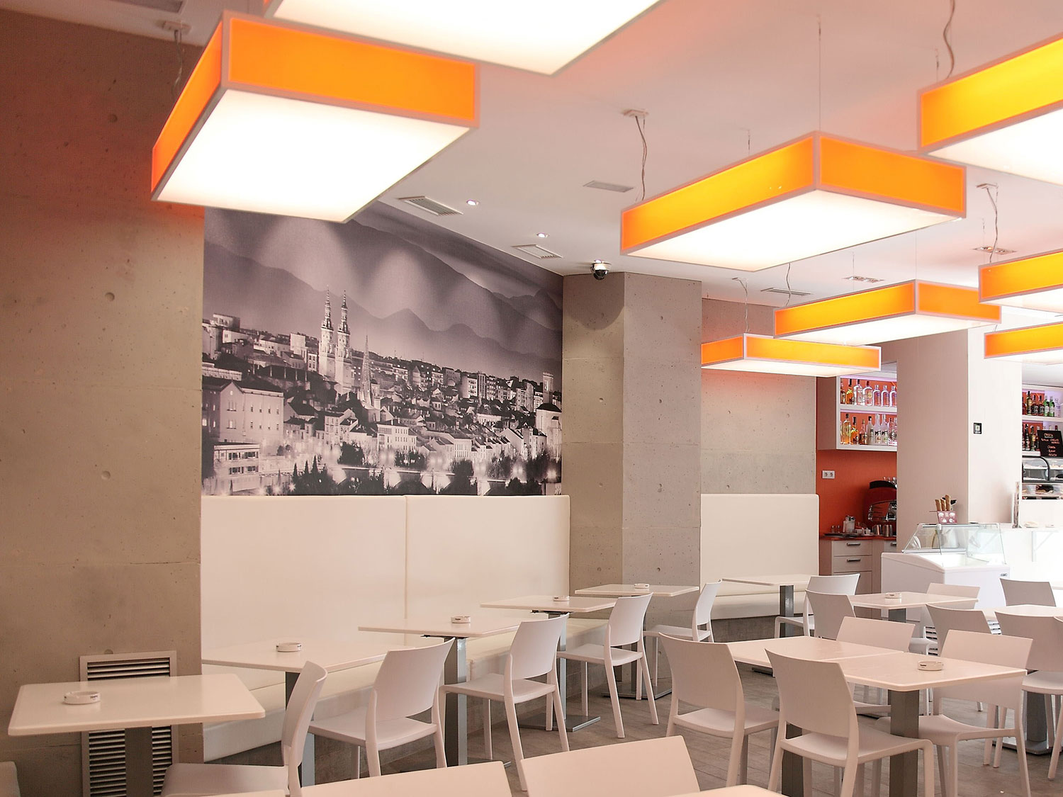 restaurant with white table and chairs and precast grey walls